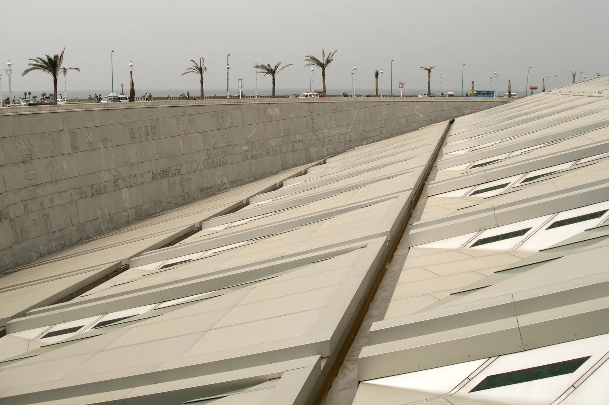 Circular stone and glass exterior of the Bibliotheca Alexandrina by the Mediterranean