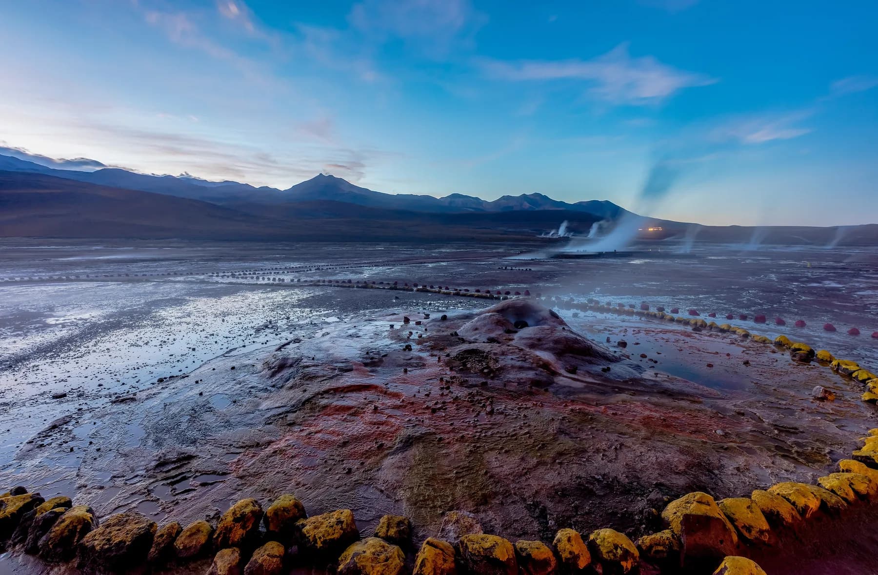 Steam rising across the El Tatio geyser field before dawn in the high Chilean Andes