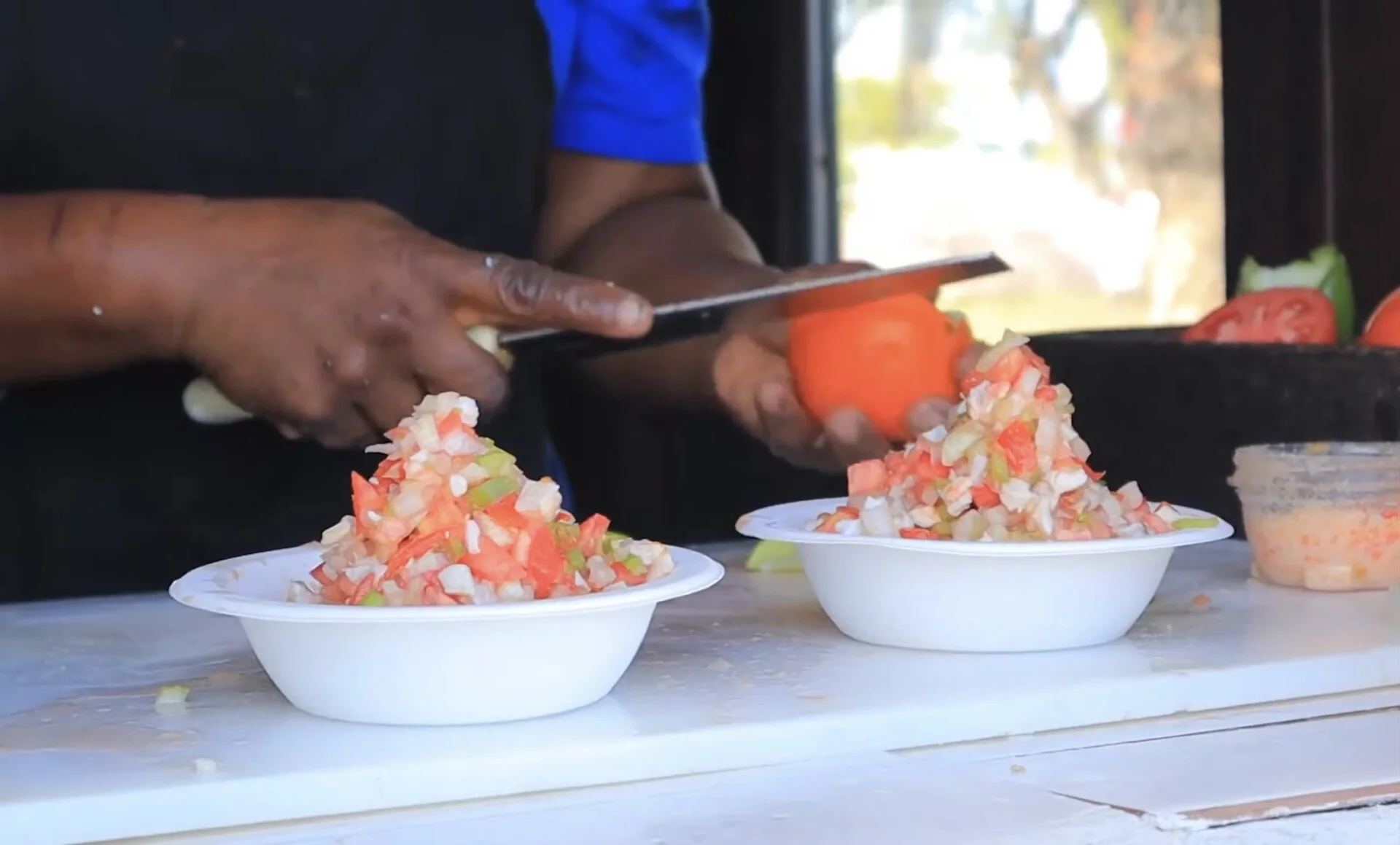 Fresh conch salad being prepared in the Bahamas with chopped vegetables on a counter