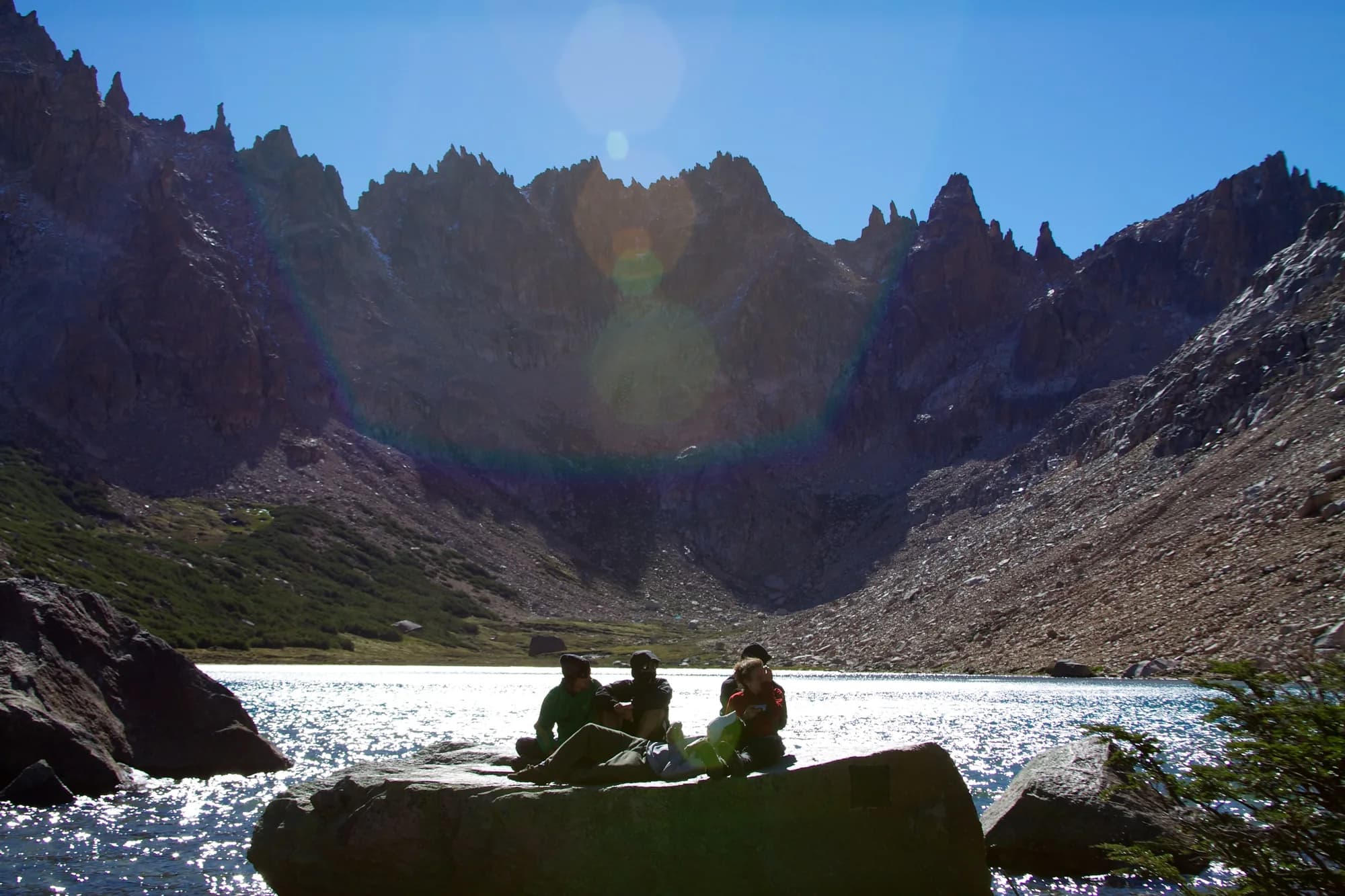 Hikers beside Frey Lake and the mountain refuge landscape near Bariloche