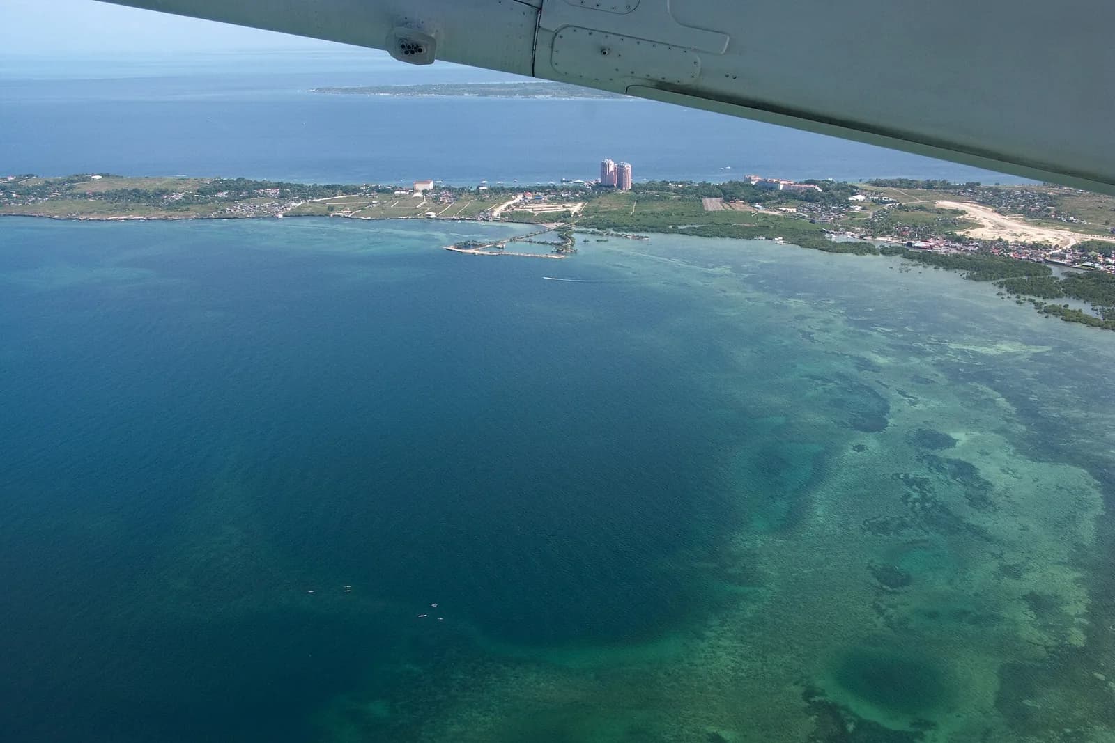 Aerial view across Cebu Island's coastline, reefs, and blue channels in the Philippines