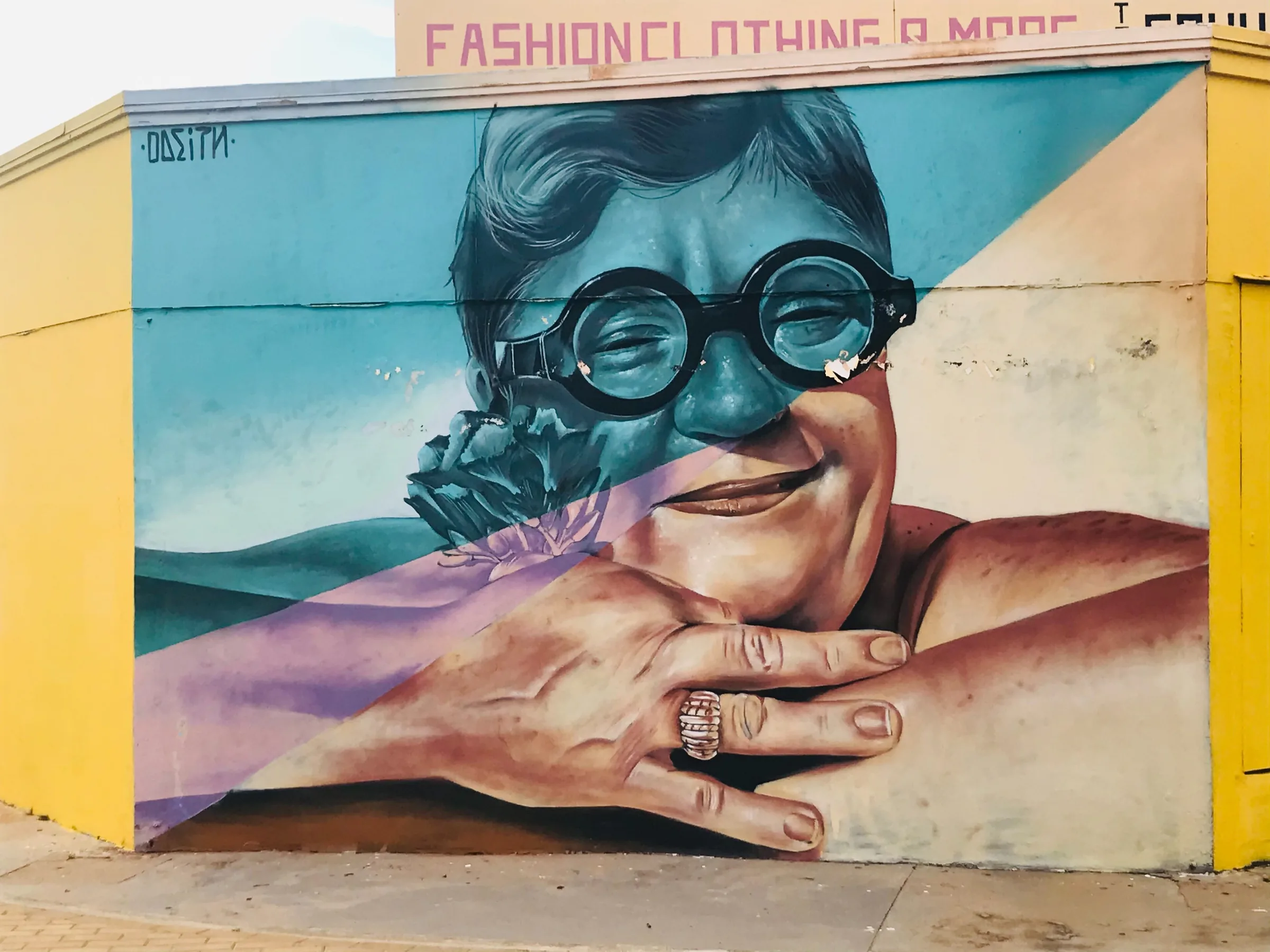 Large portrait mural painted across a colorful wall in San Nicolas, Aruba