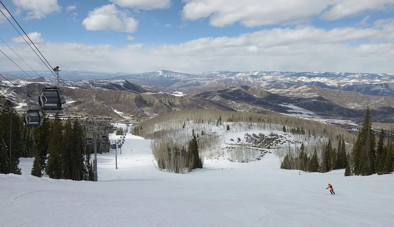 Snowmass gondola above snowy ski runs and the Elk Mountains in Colorado