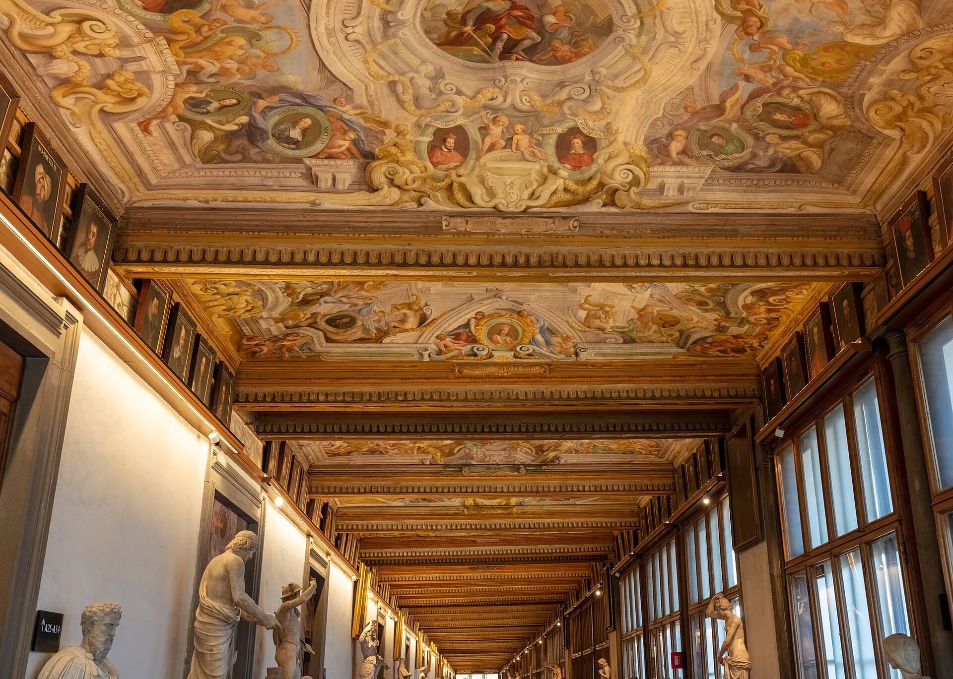Painted ceiling and sculpture-lined corridor inside the Uffizi Gallery in Florence