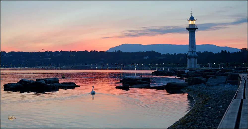Bains des Pâquis lighthouse and swimming area at twilight on Lake Geneva